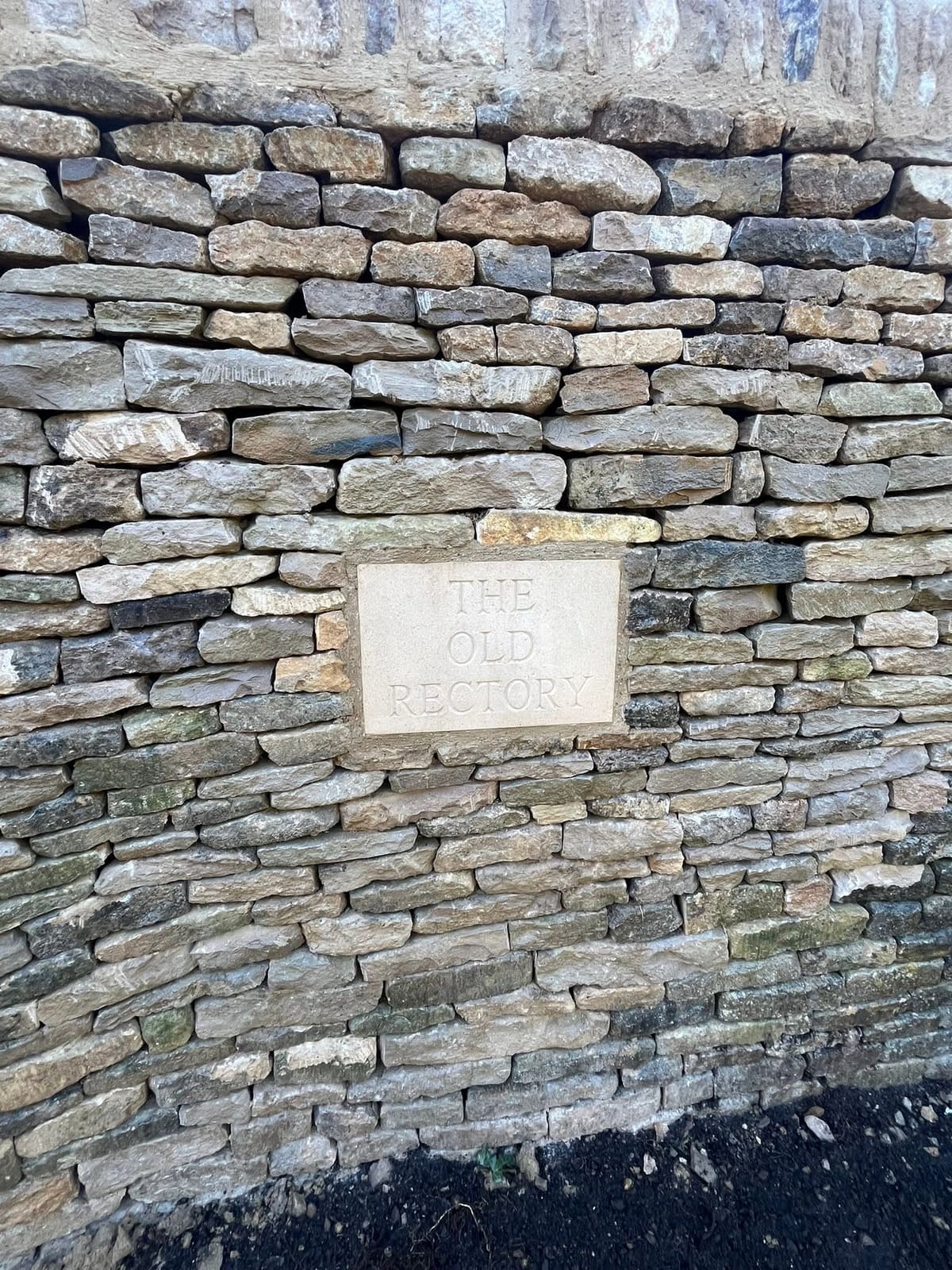 Hand-carved stone plaque reading The Old Rectory, built into the face of the new dry stone wall