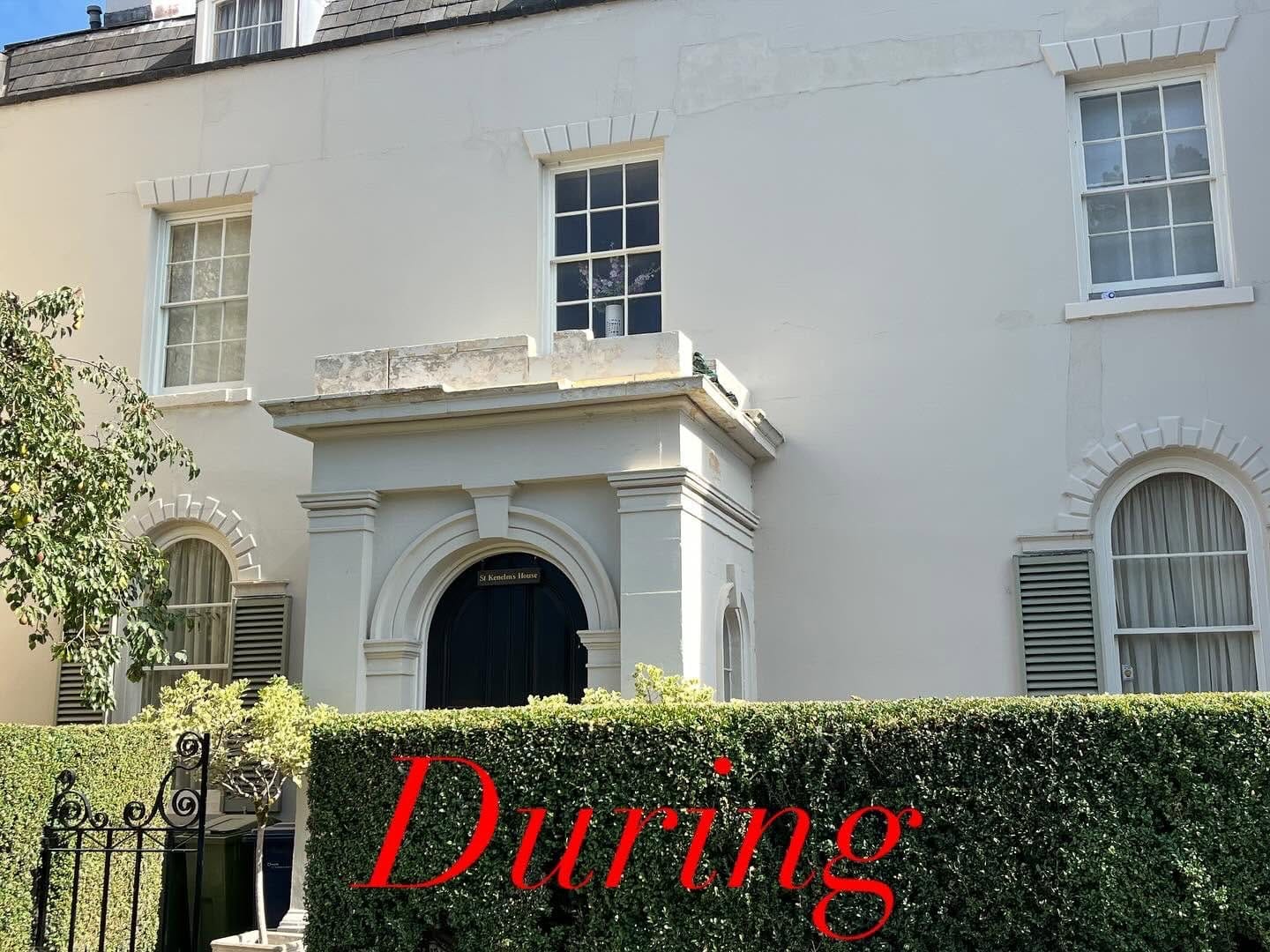 The Winchcombe house frontage during the work, porch and elevation seen from the street over the hedge